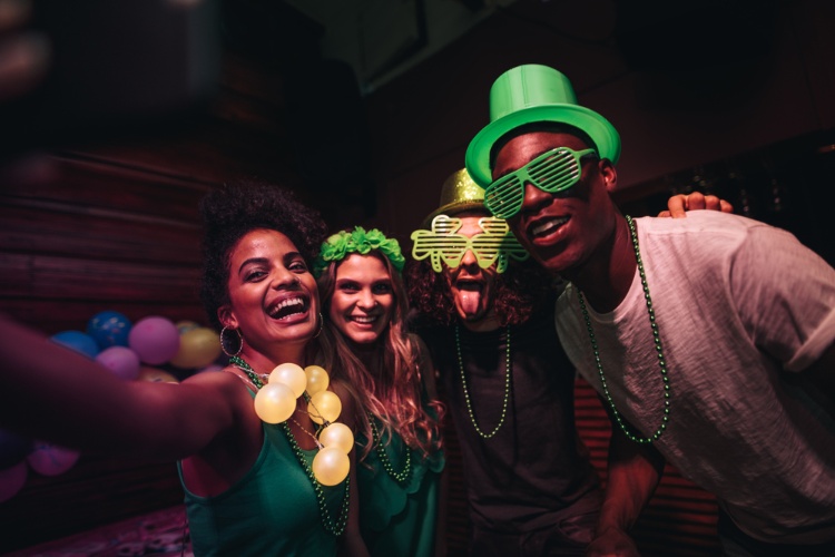 A group of people taking a St. Patricks Day themed photo.