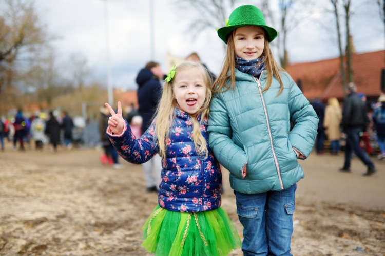Two girls pose outside with St. Patricks day inspired clothing.