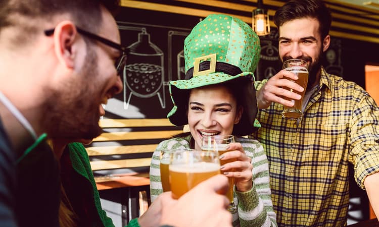 three friends toasting beer at a st patrick's day party