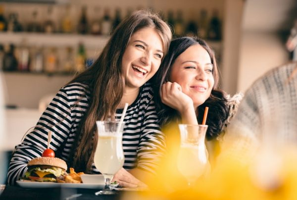 mother and daughter laugh and lean into each other during brunch in Houston, Texas