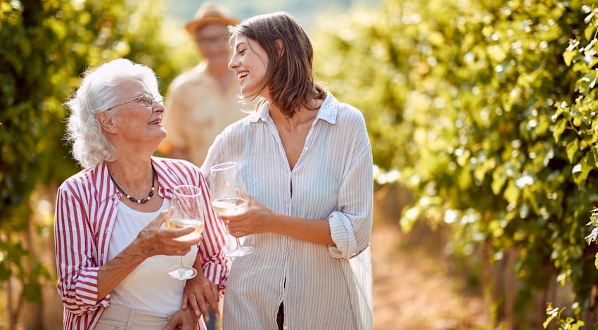 mother and daughter sip wine and walk through a vineyard outside of Houston, Texas