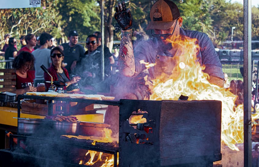 a chef seasons meat on a grill at Hot Luck Festival in Austin, Texas