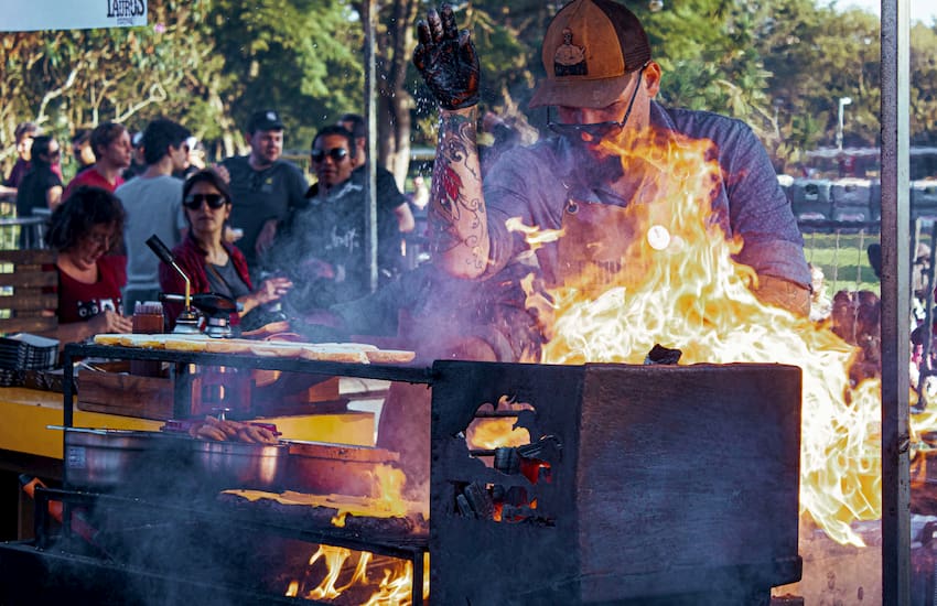 a chef seasons meat on a grill at Hot Luck Festival in Austin, Texas