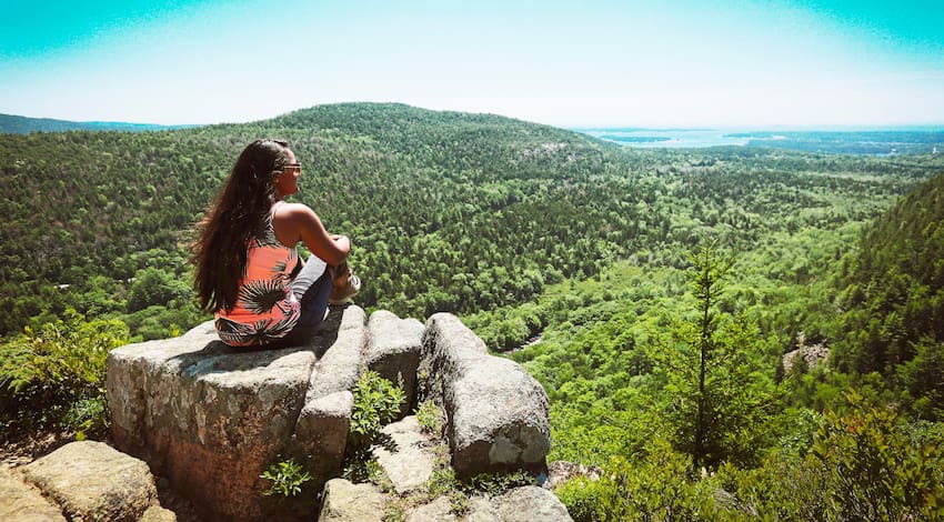 woman admires the greenery and views on top of Enchanted Rock near Austin, Texas