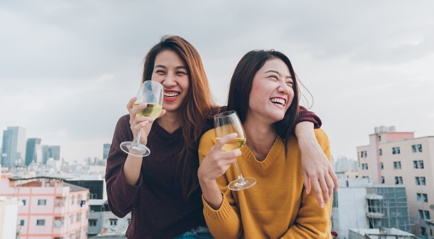 two friends sip wine on a rooftop in Austin, Texas