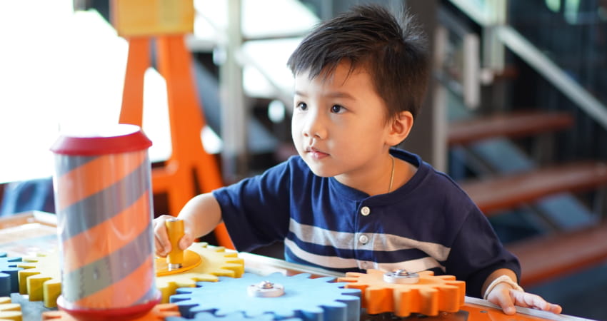 a child interacts with an exhibit in a science museum