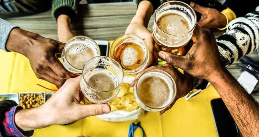 a group of people toasting beers