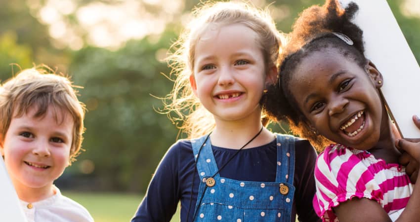 Three children smiling at a camera