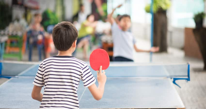 Two children playing ping pong