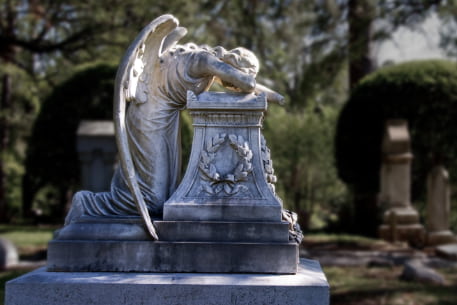 A marble angle sculpted in a crying pose on a grave at Glenwood Cemetery in Houston