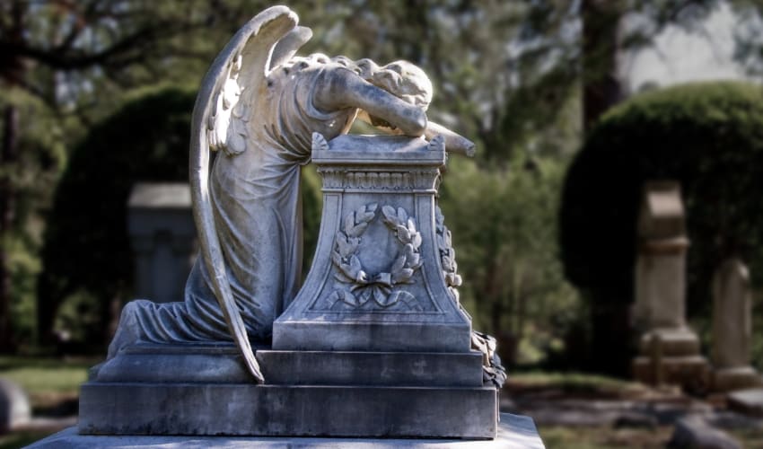 A marble angle sculpted in a crying pose on a grave at Glenwood Cemetery in Houston