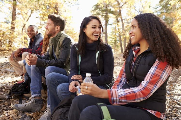 Friends dressed in fall clothing sitting outside