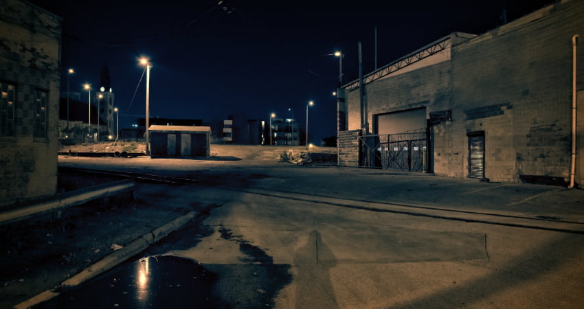 The exterior of an abandoned warehouse at night