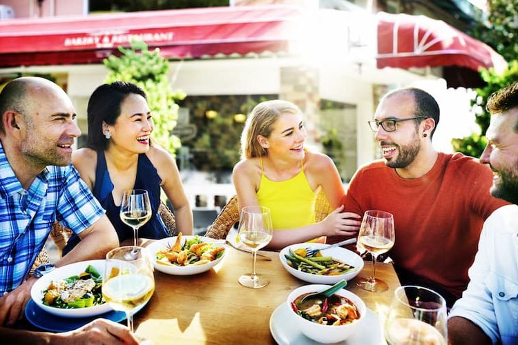 Two couples eating outside and laughing