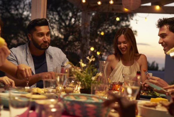 A group of friends dining on a patio in the evening