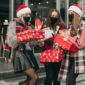 A group of friends in holiday attire and masks holding gifts