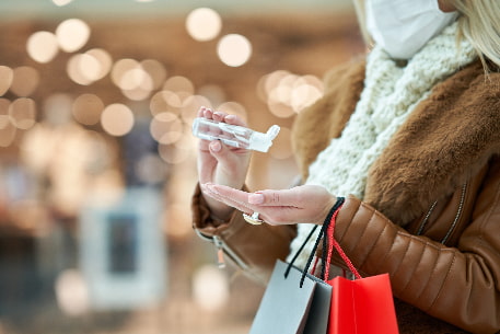 A woman sanitizes her hands while holiday shopping