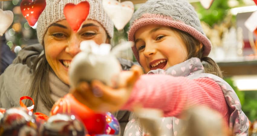 An adult and child shopping at a winter market