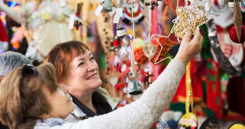 Two older women shopping at a holiday market