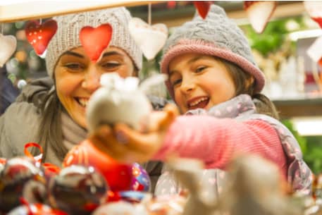 An adult and child shopping at a winter market