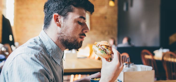 a man looks at a bbq sandwich before taking a bite