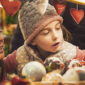 An adult and child admire Christmas ornaments at an outdoor market